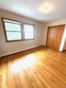 Unfurnished bedroom with a baseboard radiator, light wood-style flooring, and a closet