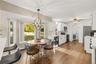 Wood-finish flooring throughout, white cabinetry, white quartz counter tops, and stainless steel appliances