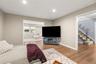Living room. Recessed lighting illuminates the wood-finish flooring