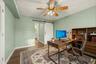 Wood-finish flooring, ceiling fan, and a white barn door. AI edited, virtually staged.