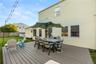Expansive Trex deck featuring integrated dining and lounge areas, anchored by a center umbrella for shade