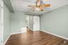 Bonus room on main level. Wood-finish flooring, ceiling fan with light fixture, sliding barn door. AI edited, all furniture removed.