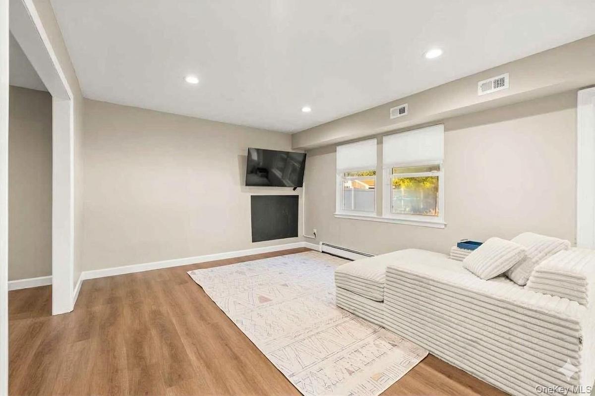 Recessed lighting, wood-finish flooring, light-toned walls. This room is currently set up as a playroom and was virtually staged as a dining room.