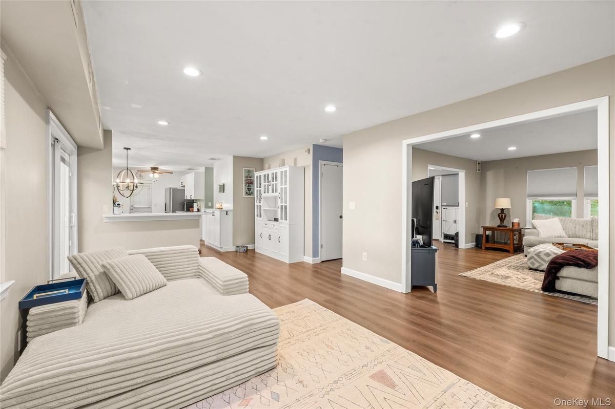 Recessed lighting, wood-finish flooring, light-toned walls. This room is currently set up as a playroom and was virtually staged as a dining room.