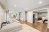 Recessed lighting, wood-finish flooring, light-toned walls. This room is currently set up as a playroom and was virtually staged as a dining room.