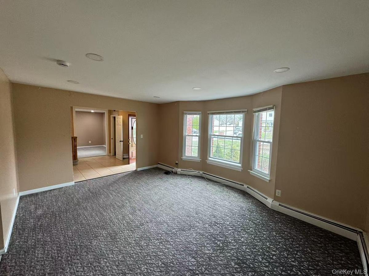 Spare room featuring baseboards and carpet floors
