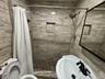Bathroom featuring a sink, a stall shower, and toilet