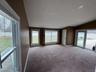 Carpeted spare room featuring baseboards and lofted ceiling