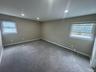 Carpeted empty room with a wealth of natural light, a baseboard heating unit, recessed lighting, and baseboards