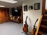 Wood slat bi-fold closet doors, drop ceiling with fluorescent lighting, wood staircase, and wood door frame