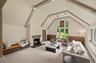 The family room features gorgeous beamed cathedral ceilings with windows overlooking the lush greenery on the back of the property.