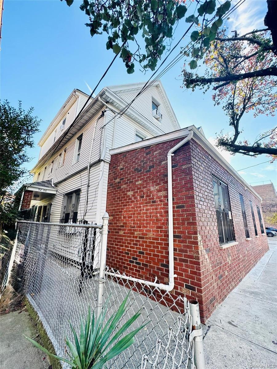 View of home's exterior with brick siding and a gate