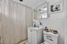 Bathroom featuring tile walls, curtained shower, vanity, and decorative backsplash
