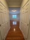 hallway with 2 walk-in closets for primary bdrm from bath