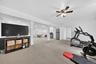 Spacious finished lower level with recessed lighting, carpeted flooring, and a ceiling fan