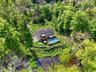 Two-story residence with solar panels, an above-ground pool with surrounding deck, and a multi-level wooden deck