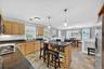 Kitchen featuring wood cabinetry, dark countertops, a central island with seating, and stainless steel appliances