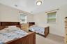 Recessed lighting, light-colored walls, built-in wooden headboards, and carpeted flooring