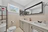 Dual vanity with integrated sinks, framed mirror, and tile backsplash