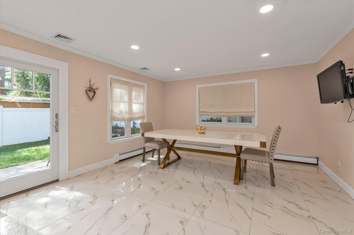 Ideal for entertaining with an open floor plan, crown molding, recessed lighting, and sliding glass doors to patio.