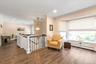 Sprawling living room area with large bay windows.