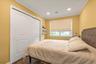 Bedroom #2 Recessed ceiling lighting, crown molding, white trim, sliding panel closet doors, and wood-finish flooring
