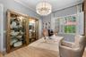 Den/Office — Built-in display cabinets and windows with plantation shutters.