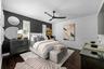 Dark wood flooring, accent wall, and windows with plantation shutters.