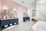 Primary Bathroom - Dual navy vanities, freestanding soaking tub, and arched opening to the bedroom.