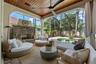 Lounge seating, stacked-stone fireplace, and arched openings to the pool.