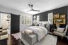 2nd Bedroom with dark accent wall, sliding barn door, ceiling fan, and plantation shutters.