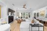 Fireplace with mounted TV above, built-in shelving, and French doors to the pool area.