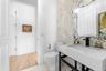 Pool bathroom — Console vanity with stone top and decorative mirror.