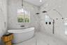 Primary Bathroom - Wet-room layout with freestanding tub, dual rain showerheads, handheld sprayer, and patterned mosaic tile floor.