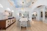 Dining area with arched windows and a sightline through to the kitchen and family room.