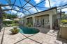 Screen-enclosed pool with brick paver deck and covered lanai.