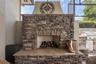 Outdoor fireplace — Stacked-stone wood-burning fireplace with raised hearth on the lanai.