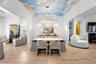 Sky ceiling mural, arched clerestory windows, and built-in cabinetry with open shelving.