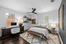 3rd Bedroom with desk area, floating wood shelves, and dark wood flooring.