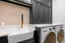 Laundry Room - Farmhouse utility sink with brass faucet, tile backsplash, and upper cabinet storage.