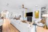 Fireplace with built-in shelving, ceiling fan, and French doors to the covered lanai.