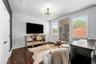 Sitting area with mounted TV and windows with plantation shutters.