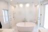 Spa Inspired Primary Bathroom featuring a freestanding stone soaking tub and oversized glass-enclosed walk in shower. And a Private enclosed water clo
