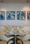 Built-in banquet seating, round pedestal table, and recessed ceiling lighting
