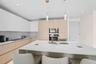Kitchen featuring an oversized island, integrated appliances, recessed lighting, pendant lighting, and two-tone cabinetry
