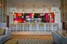 Integrated bar area with white countertop, colorful geometric paneling, and multiple pendant light fixtures