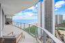 Expansive balcony with glass panel railing and ocean scenery