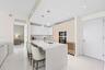 Sleek kitchen with a waterfall island, integrated stainless steel appliances, and a built-in wine cooler