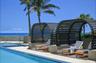 Swimming pool with integrated spa, adjacent to a patio featuring two covered lounge structures