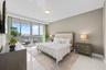 Floor-to-ceiling sliding glass doors, white tile flooring, recessed ceiling lighting, and a neutral wall color